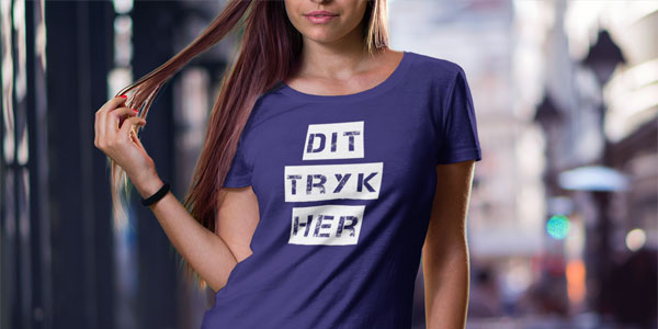 Kvinde iført en lilla figursyet T-shirt med eget tryk i et urbant bymiljø